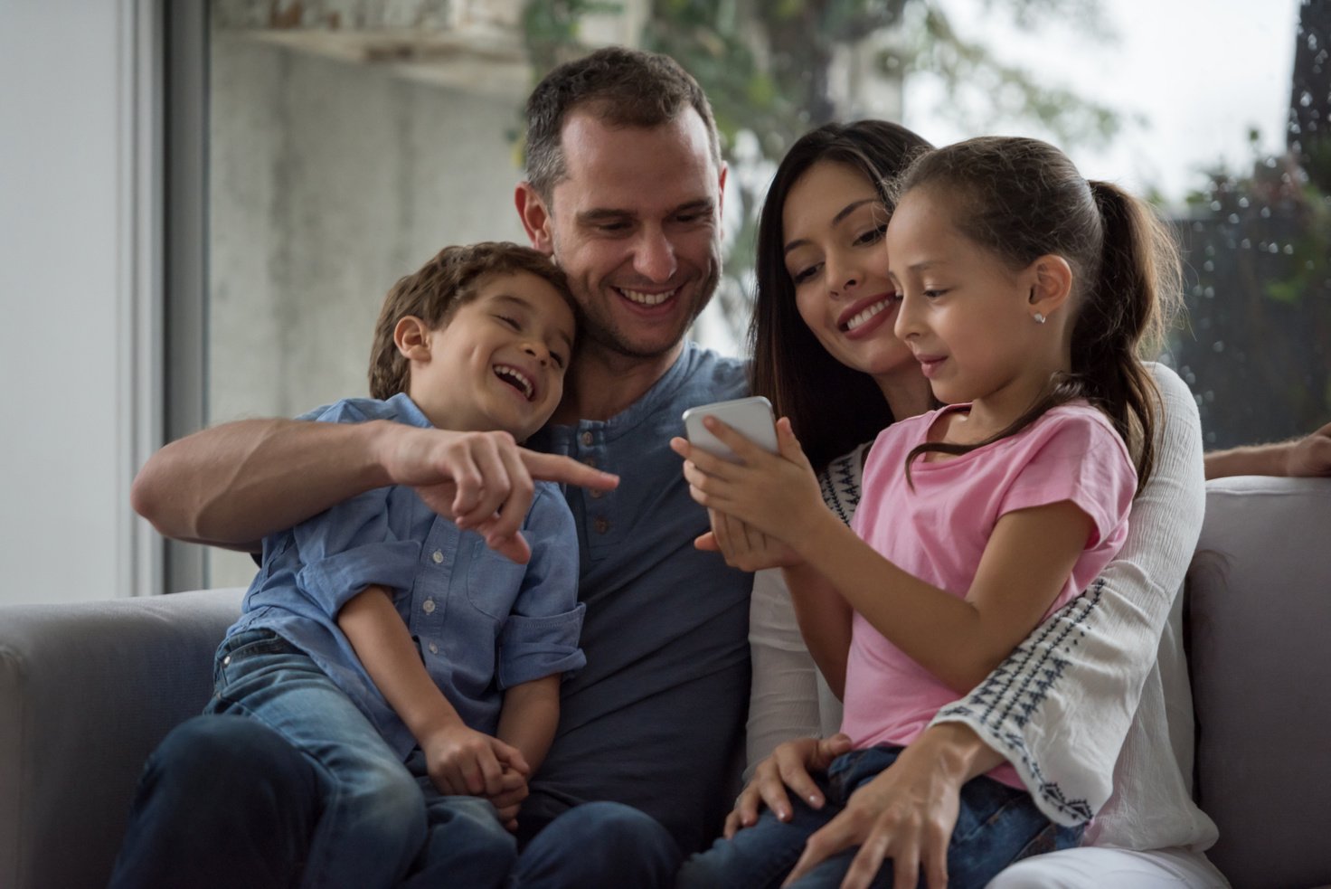 Family at home watching social media on a cell phone